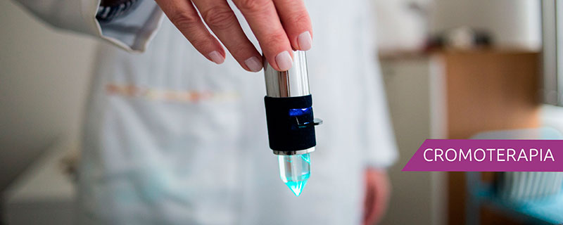 Imagem com um profissional segurando um aparelho que é utilizado na cromoterapia